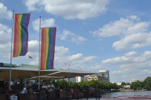 Margem do Alster, semana do Orgulho LGBT. Ao fundo, atrás das bandeiras, a Neuer Jungferntieg.